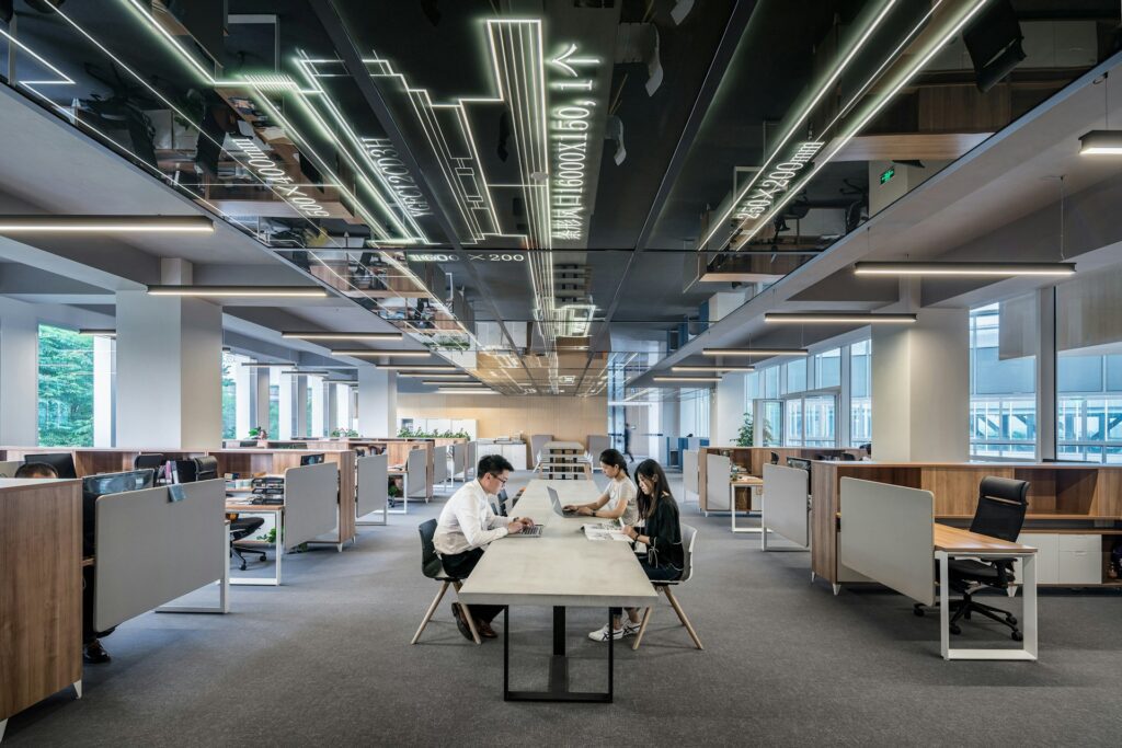 three people working on laptops in an office