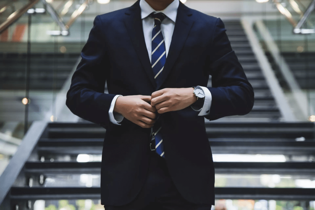 Man in suit at base of office lobby staircase