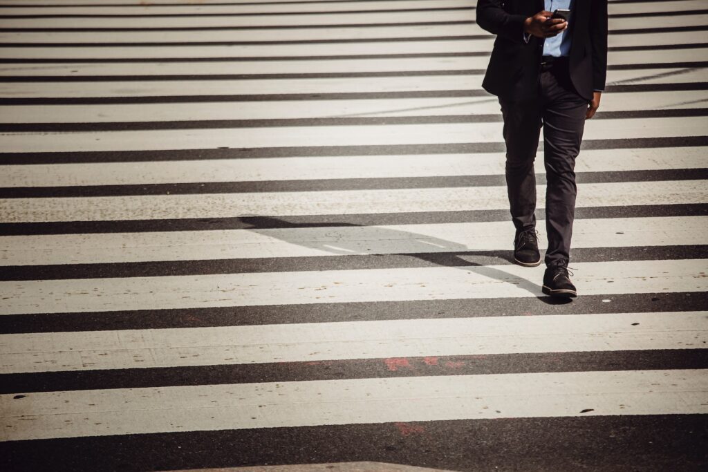 Faceless man in suit crossing the street
