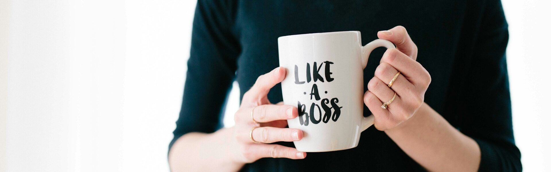 Woman holding a mug that says, Like A Boss.