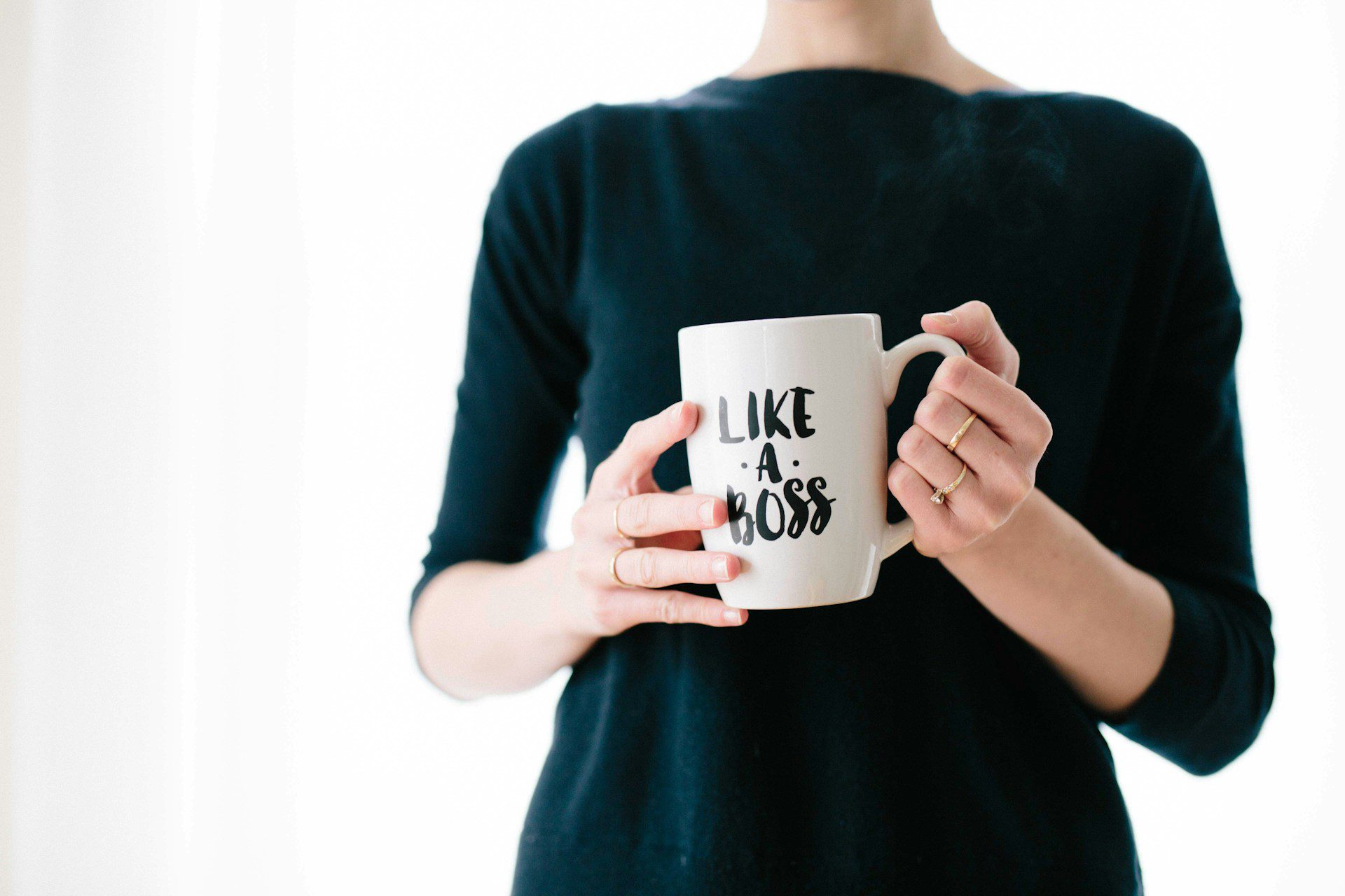 Woman holding a mug that says, Like A Boss.