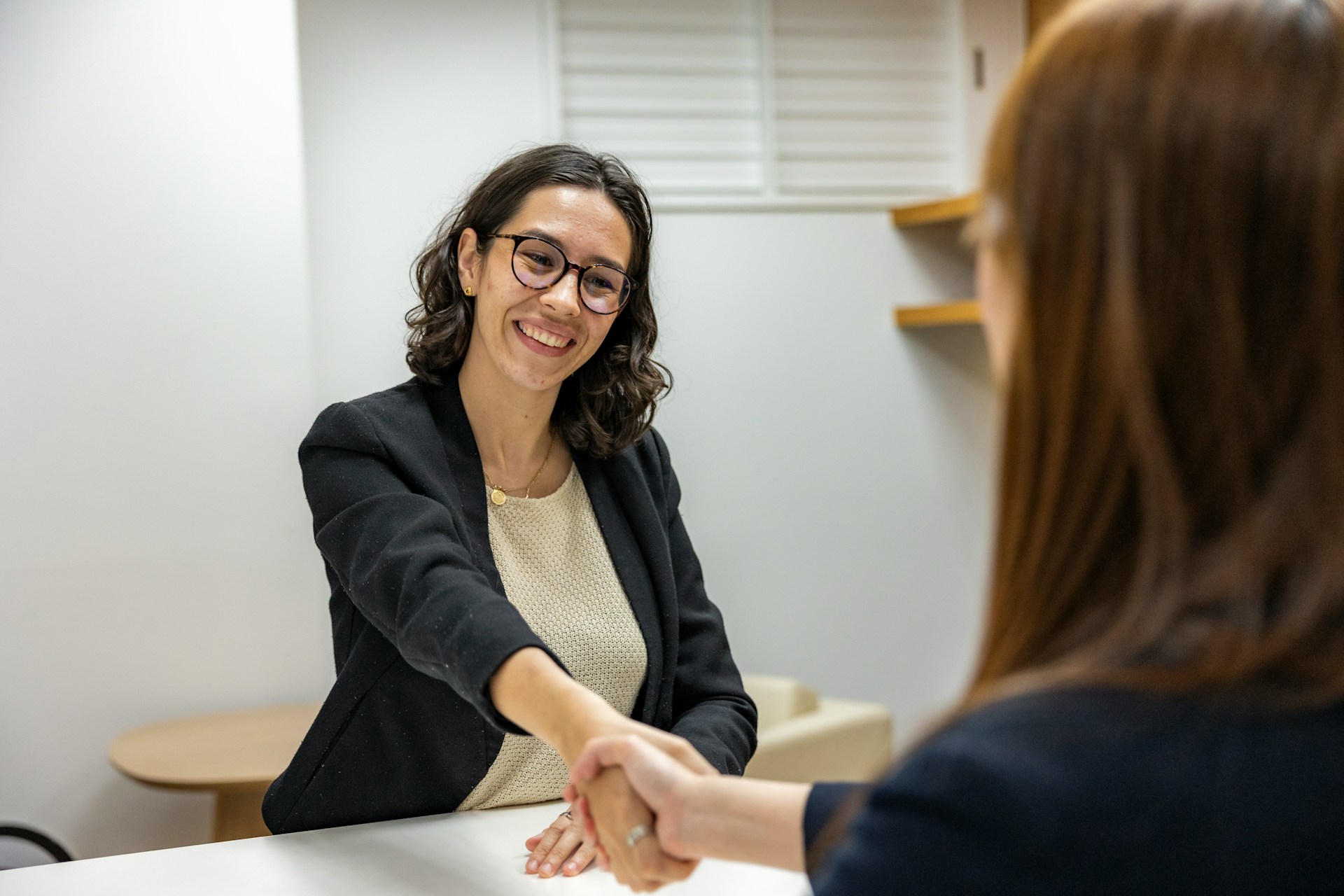 Hiring manager shaking hands with job candidate during interview