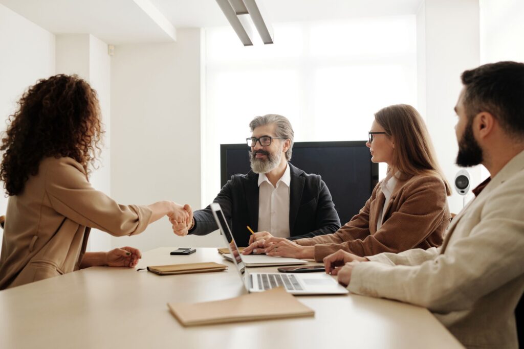Hiring manager shaking hands with candidate during an office interview