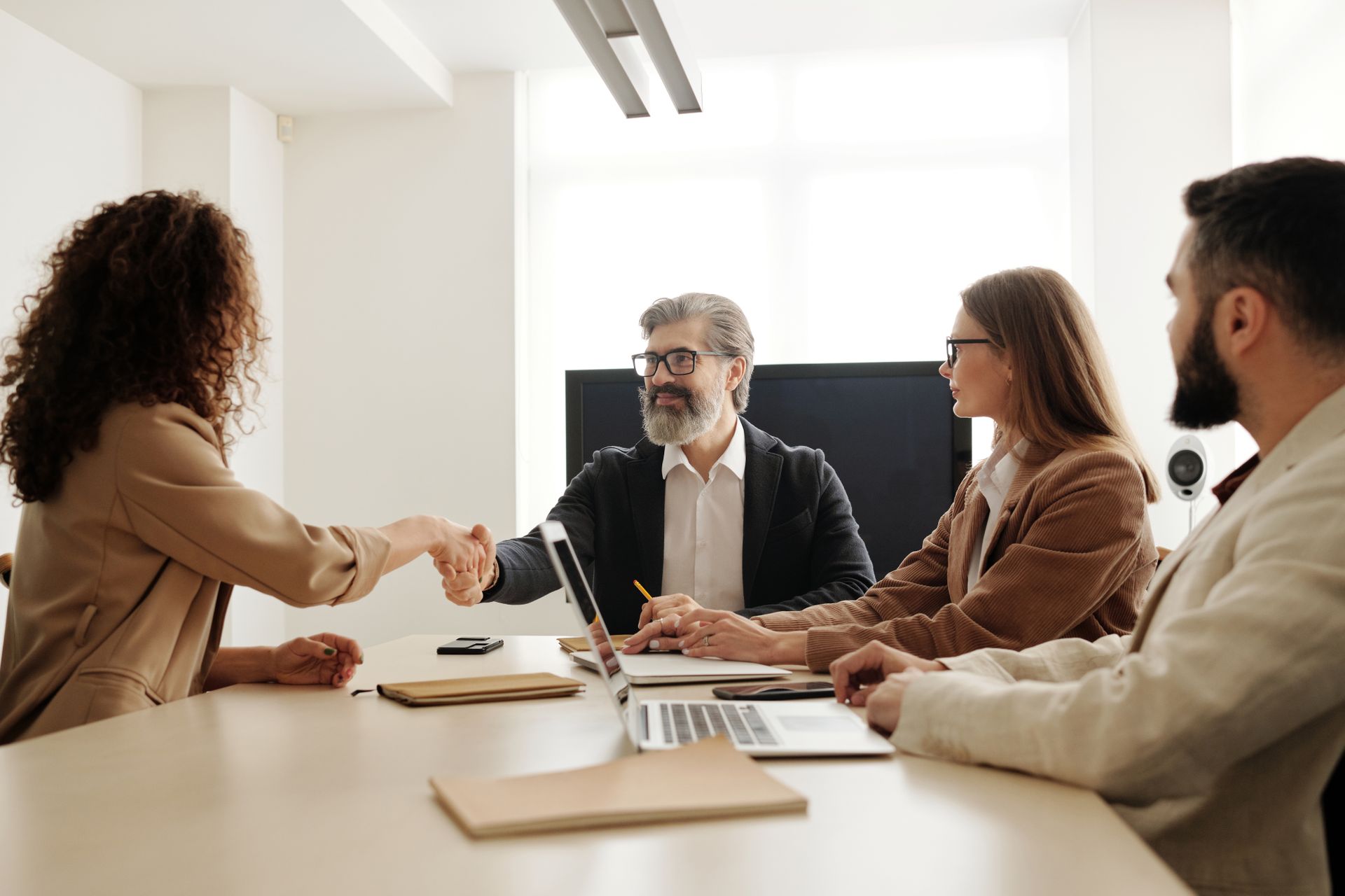 Hiring manager shaking hands with candidate during an office interview